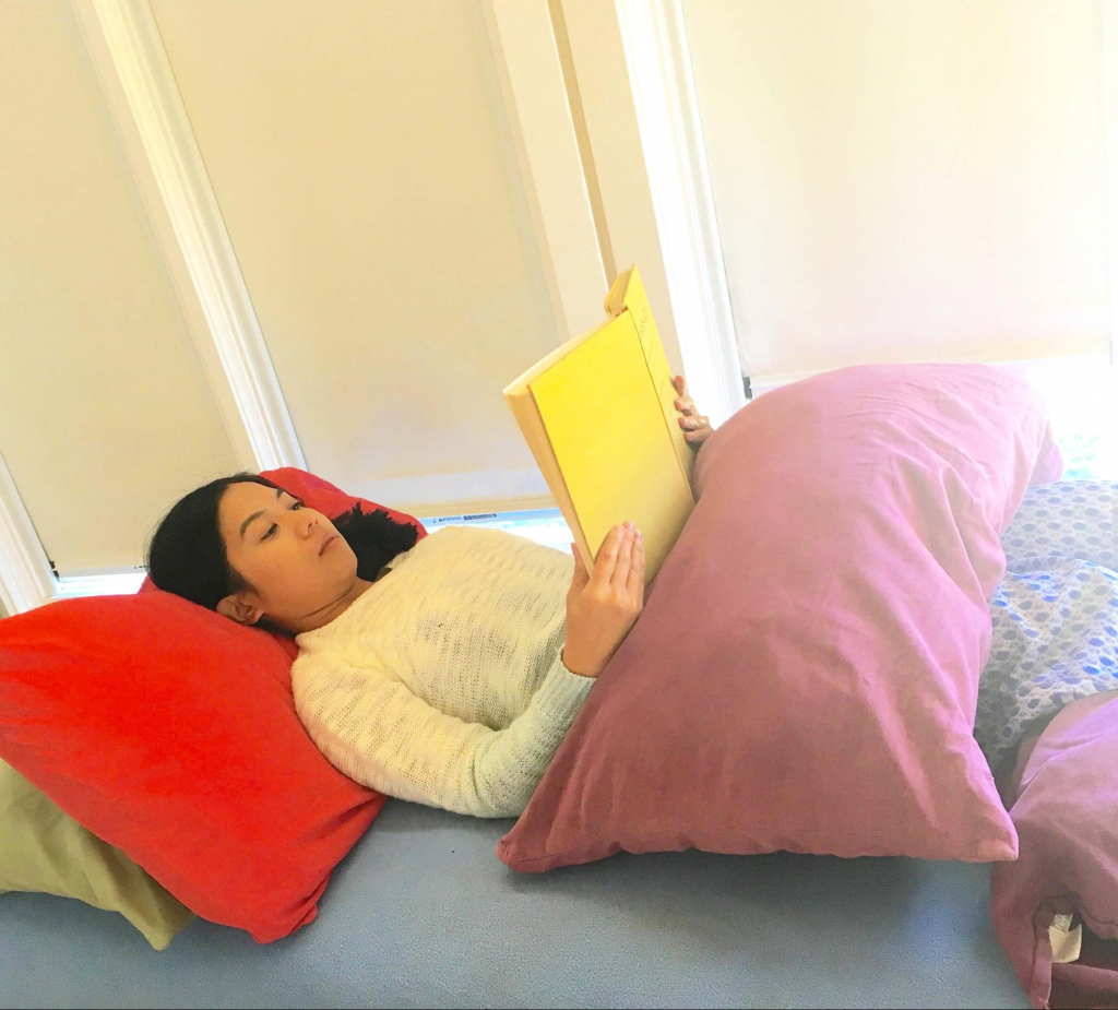 Pillow on the chest or knees supports book, rests arms