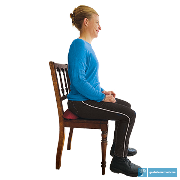 Female student sitting on a dining chair with the Gokhale Wedge