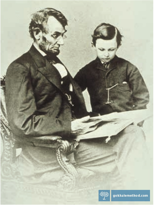 Photo of Abraham Lincoln reading with his son.