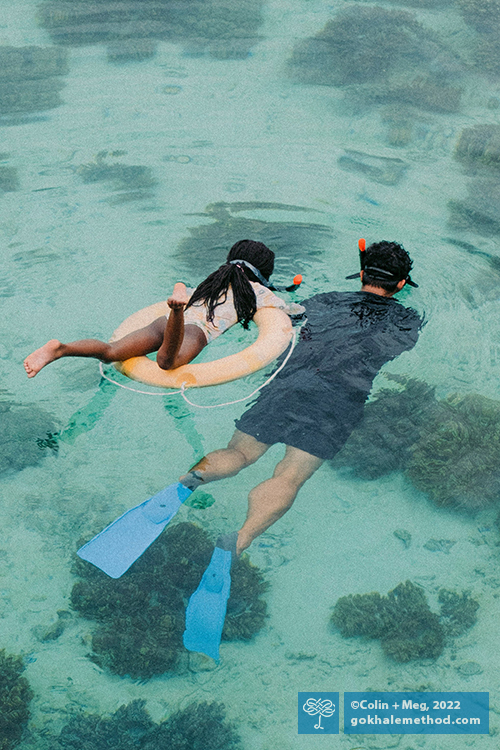 Man and young girl snorkeling, from above.