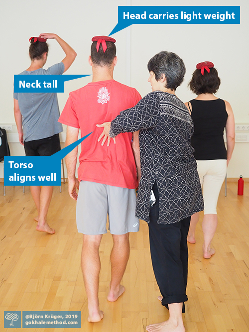 Student learning to head-load in glidewalking, guided by Esther Gokhale.