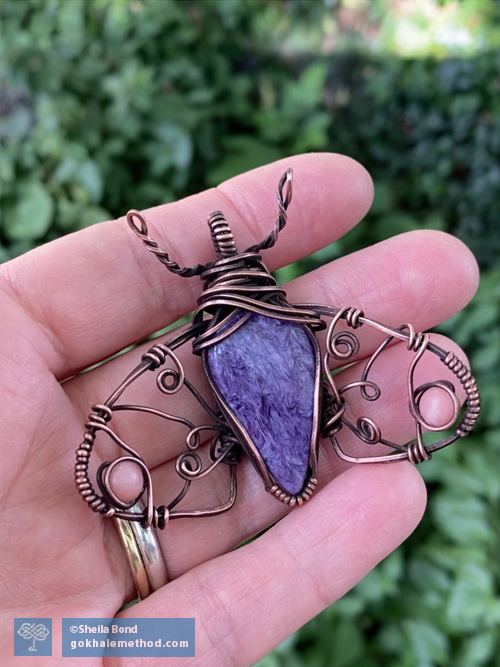 Sheila Bond holds a charoite and copper pendant she made.