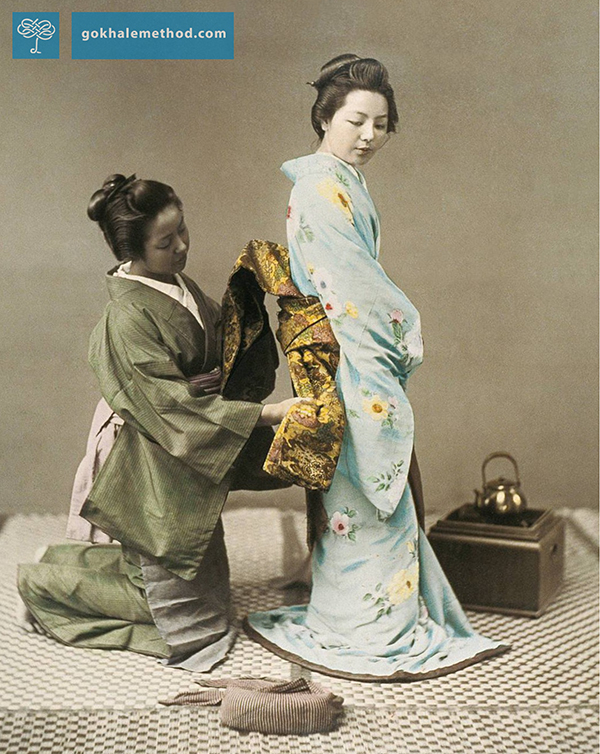 A Japanese woman tying the obi (sash) of a geisha in the 1890s. 